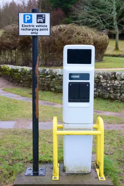 Electric vehicle car recharging point sign and charging station to plug in at car park