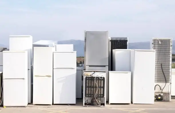 Photo of Fridges stacked in a row for recycle used refrigeration units pollution gas