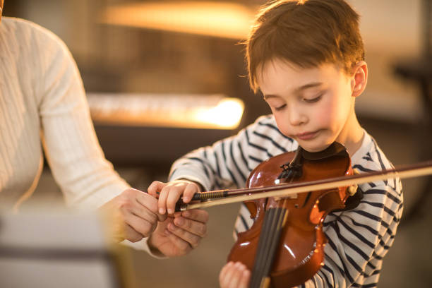 istock School boy learning to play the violin 937093426