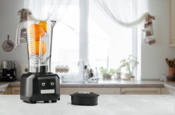 istock Blender and orange on wooden table in kitchen 937093488