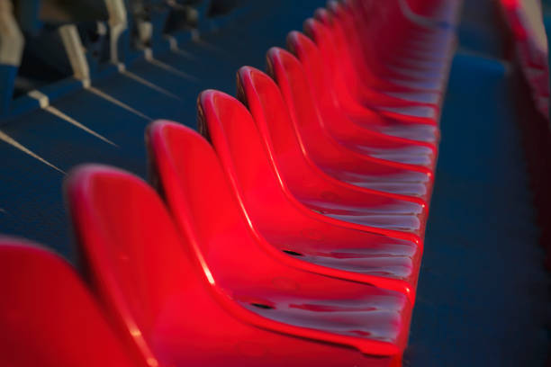 Rows of empty bright plastic chairs, seats on stadium, diagonal Background, selective focus