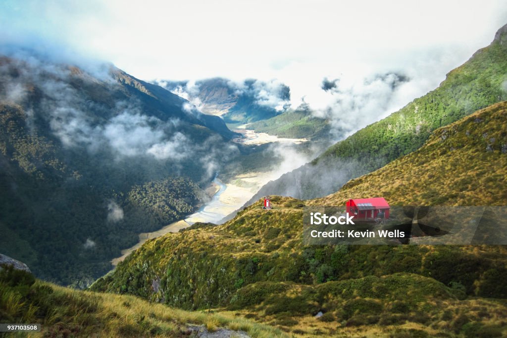 Backcountry Hut on the Edge of a Cliff in New Zealand A backcountry hut sits on the edge of a large cliff in the Matukituki Valley in Mt. Aspiring National Park, New Zealand. New Zealand Stock Photo