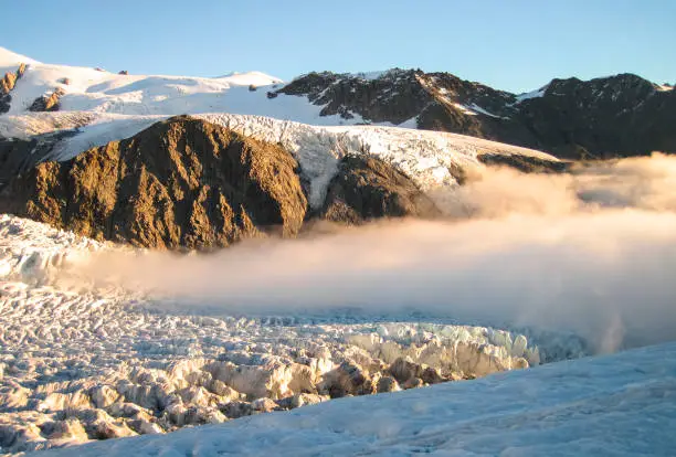 Photo of Dense Clouds Cover the Fox Glacier at Sunset in New Zealand