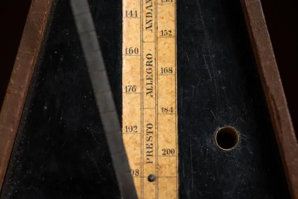 Detail of an old mechanic musical metronome, scale showing the various tempos