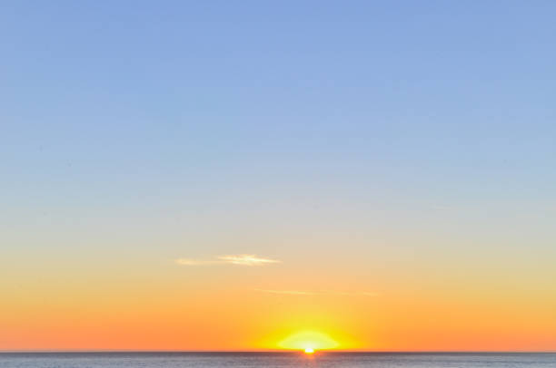 istock clear sky at sunset with the sun just peeping over the horizon 937107764
