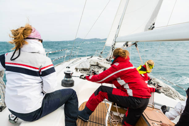 donna che tira la corda sul corso di vela - squadra di vela foto e immagini stock