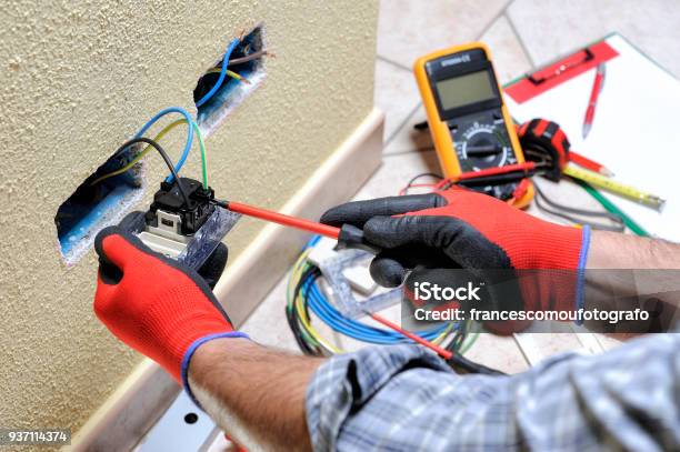 Tecnico Elettricista Al Lavoro Con Attrezzature Di Sicurezza Su Un Impianto Elettrico Residenziale - Fotografie stock e altre immagini di Elettricità