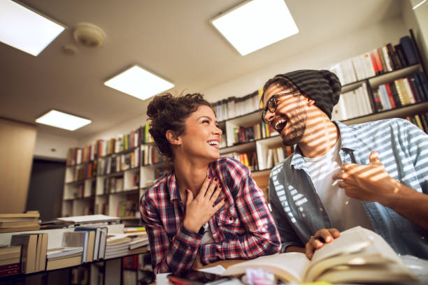 istock Lovely couple study at library, looking each other smiling. Education with partner, friends. 937117714