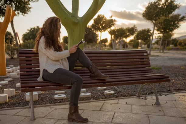 istock sitting in a park at sunset reading 937121334