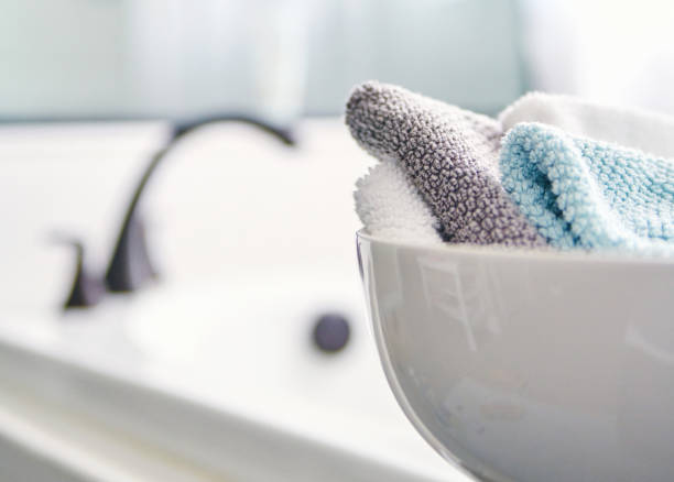 Bright airy modern spa like bathroom with folded wash clothes