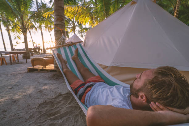 istock Man relaxing in hammock in clamping site luxury camping 937130990