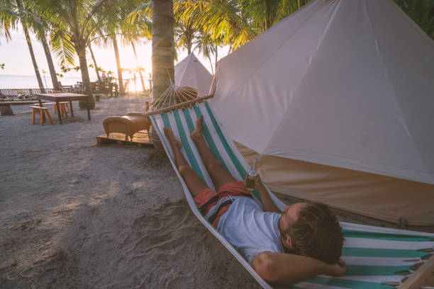 istock Man relaxing in hammock in clamping site luxury camping 937130994