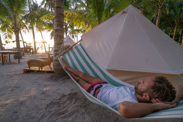 istock Man relaxing in hammock in clamping site luxury camping 937130996