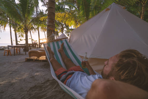istock Man relaxing in hammock in clamping site luxury camping 937132414
