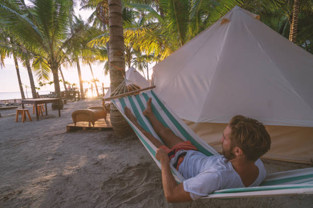 istock Man relaxing in hammock in clamping site luxury camping 937133122