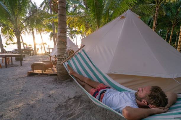 istock Man relaxing in hammock in clamping site luxury camping 937133142