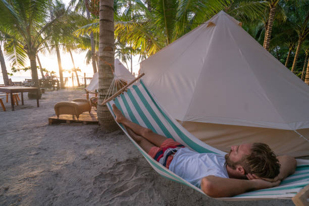 istock Man relaxing in hammock in clamping site luxury camping 937133190