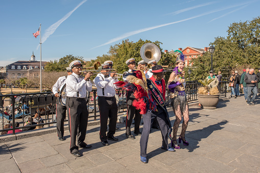 New Orleans, LA, January 25, 2018: A brass band performs on Riverwalk at Jackson Square, in the French Quarter. Street musicians are common and beloved in New Orleans. The woman holds a chihuahua.