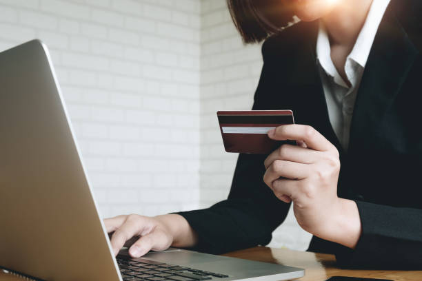 Hands holding plastic credit card and using laptop. Online shopping concept. Toned picture Hands holding plastic credit card and using laptop. Online shopping concept. Toned picture tienda stock pictures, royalty-free photos & images