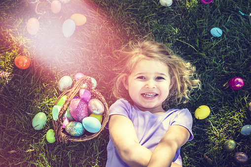 A stock photo of some young girl having fun at an Easter egg hunt