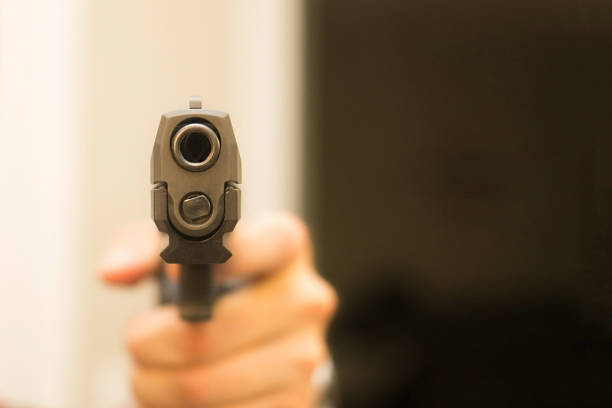 istock Hand gun pointing indoor home violence 937150784
