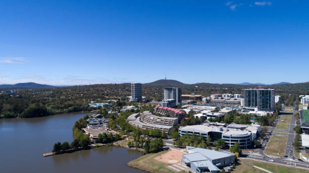 Aerial Belconnen suburb from Lake Ginninderra High aerial viewpoint photographed by a DJI Phantom 4pro, looking towards buildings and cars moving around, a few people in the distance, Telstra tower in the background, a few retail shops on the lake, photographed on a nice sunny day. belconnen stock pictures, royalty-free photos & images