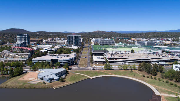 Aerial of Belconnen Town Centre from Lake Ginninderra High aerial viewpoint photographed by a DJI Phantom 4pro, looking towards buildings  and cars moving around, a few people in the distance, Telstra tower in the background and Westfield belconnen mall to the right and belconnen gallery to left with residential units,on a nice sunny day. belconnen stock pictures, royalty-free photos & images