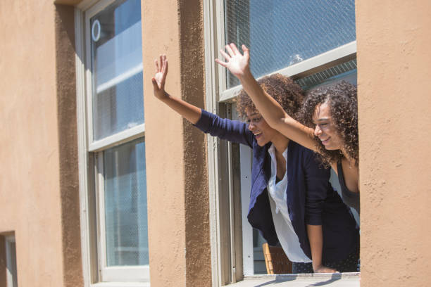 istock Women Waving from an Apartment Building Window 937182124