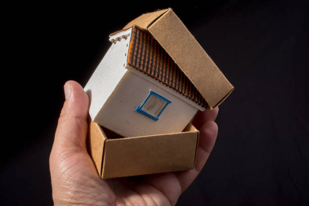 istock Little model house in hand in a box 937193618