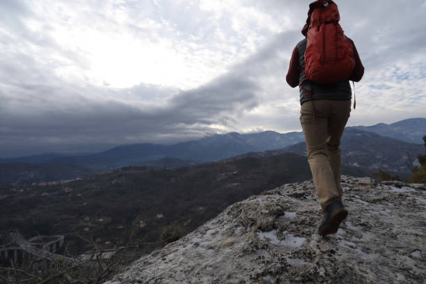 istock Young man hikes out to rock buttress with backpack 937198766