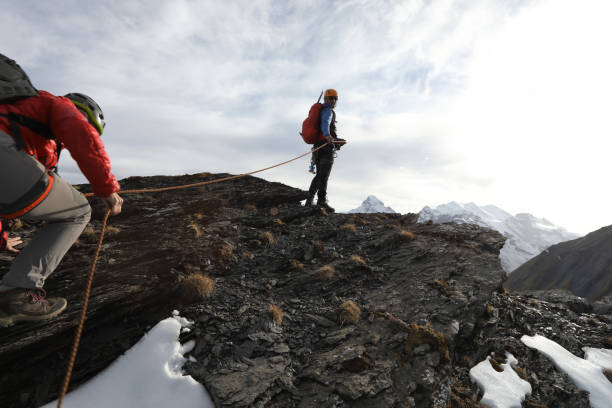 Female mountaineer climbs to summit belay