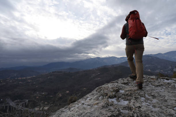 istock Young man hikes out to rock buttress with backpack 937198838