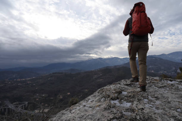 istock Young man hikes out to rock buttress with backpack 937198842