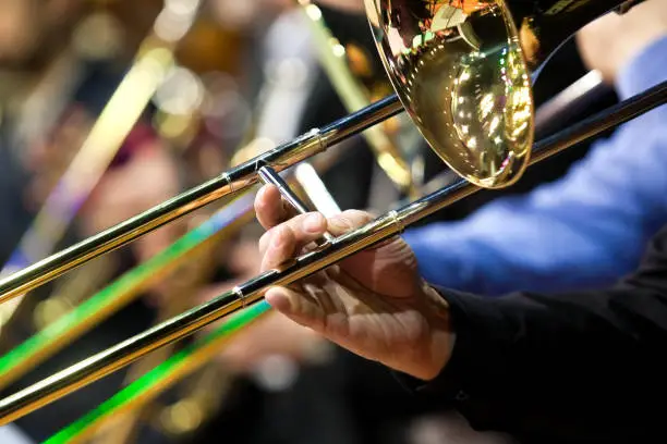 Photo of Fragment of a trombone in the hands of a musician