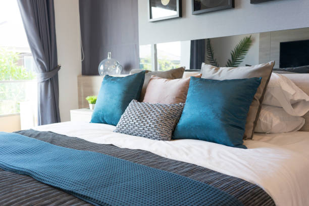 luxury set of blue and gray pillows on bed in stylish bedroom
