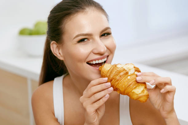 istock Diet. Happy Woman Eating Croissant For Breakfast. 937202512