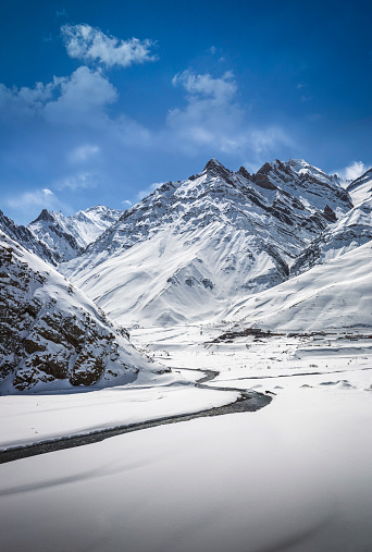 a view of frozen river and snow mountain of spiti valley in winter in india