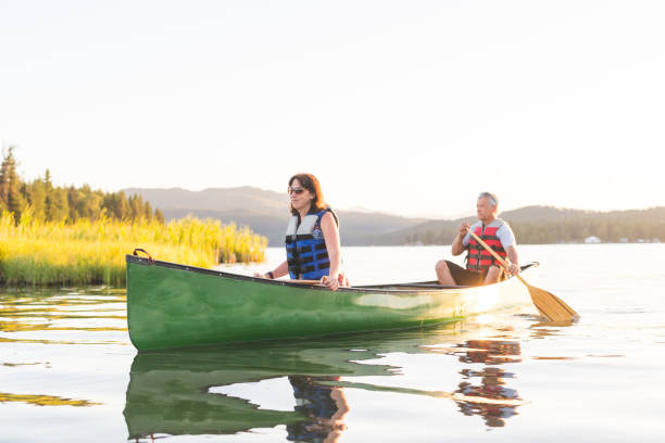 istock Older couple canoe together on a lake 937207060