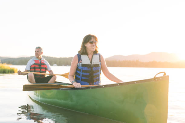 istock Middle-aged couple canoe together on a lake 937207080