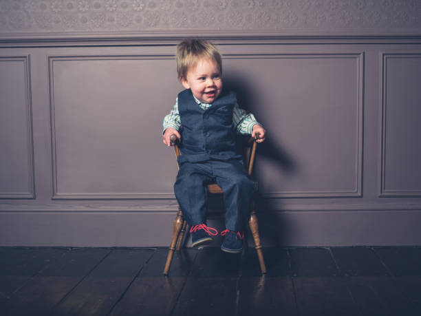 istock Smiling little boy sitting on a chair 937209370