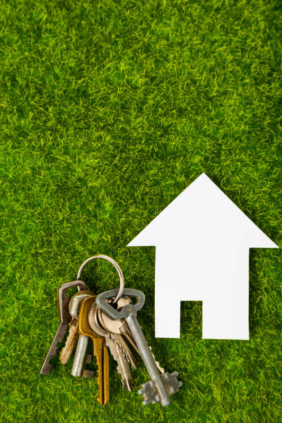 istock Cardboard house and keys on grass 937210426