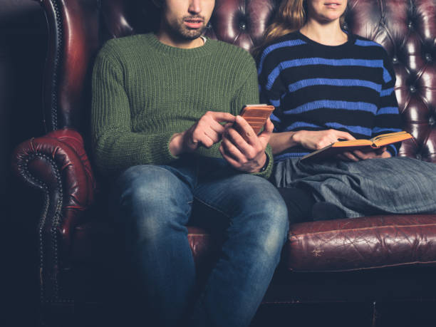istock Young couple reading and using phone 937217316