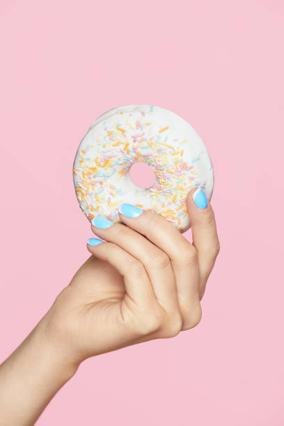 istock Manicure. Hand With Blue Nails Holding Donut 937217526