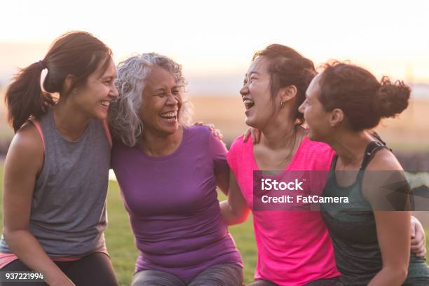 Cuatro Mujeres Étnicas Riendo Juntos Después De Un Entrenamiento Al Aire Libre Foto de stock y más banco de imágenes de Sólo mujeres