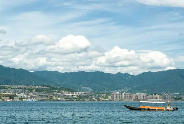 Traditional old Japanease boat in the water in front of the Miyajima island, in Hiroshima bay, Japan.