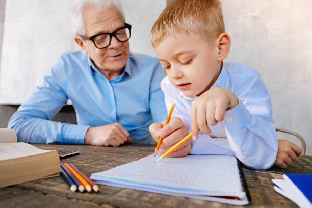 istock Positive nice grandfather helping his grandson 937222606