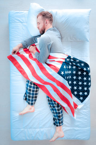 Dreams about country. Sleepy man keeping eyes closed and lying on the side while dreaming about trip