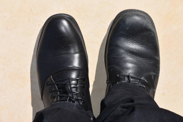 istock Businessman looks down at different shoes 937230246