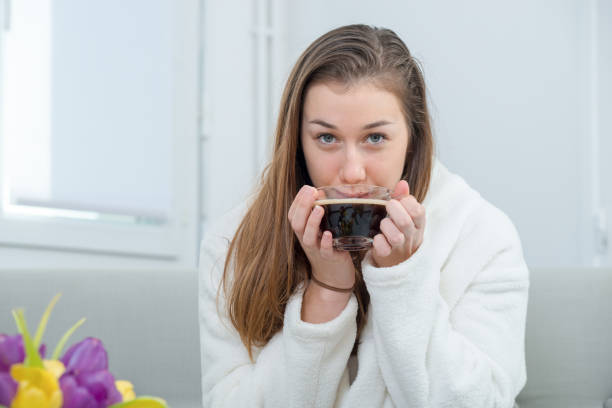 istock at morning, a young and smiling woman drinking a coffee 937230394