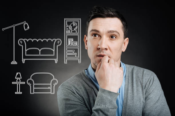 Calm man touching his lip while thinking of moving